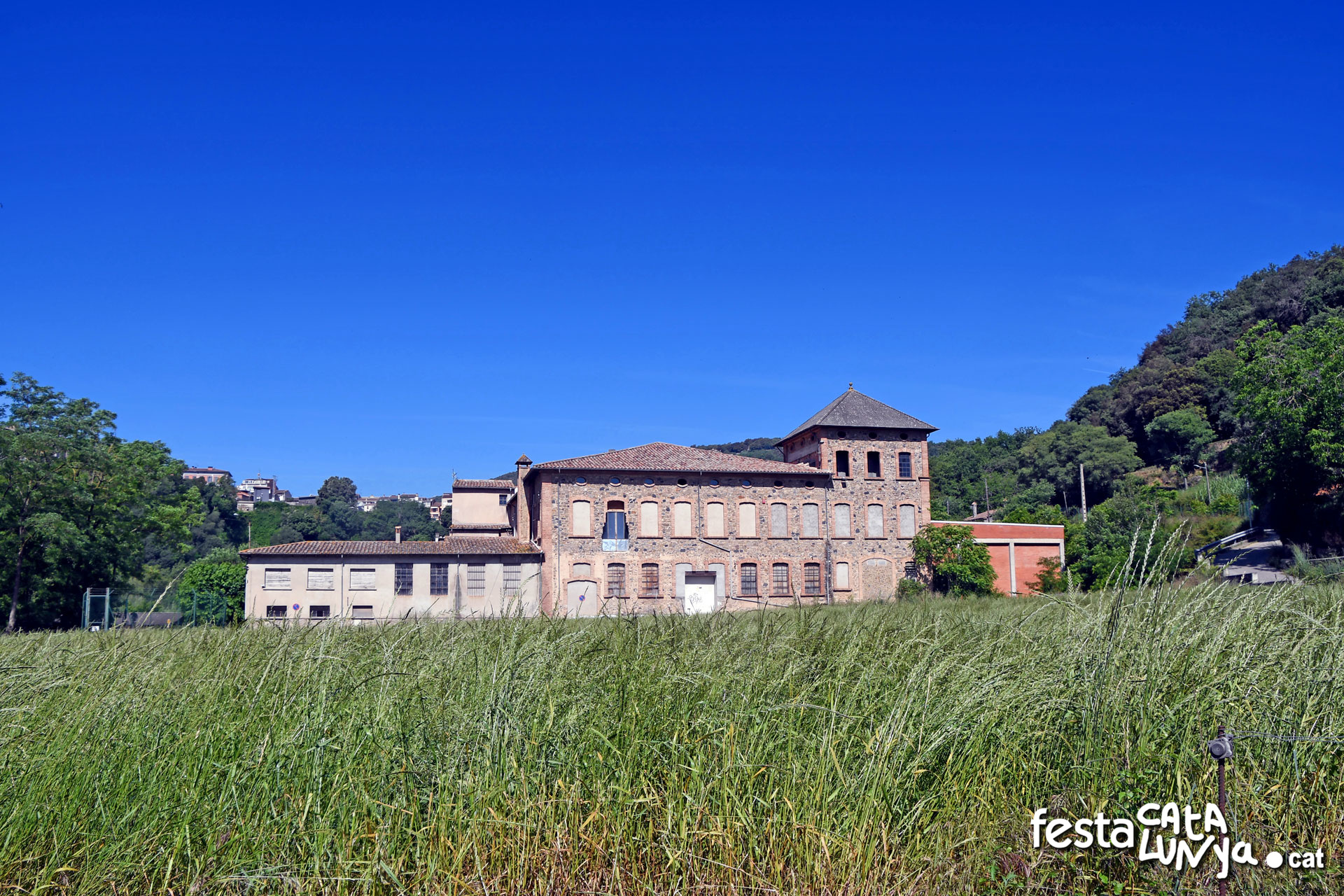 La Fàbrica als peus del cingle basàltic de Castellfollit a Montagut i Oix